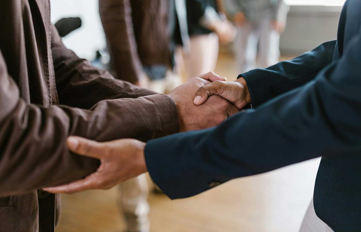 ExitMax Advisors Platform background showing two people shaking hands and selling or buying a business