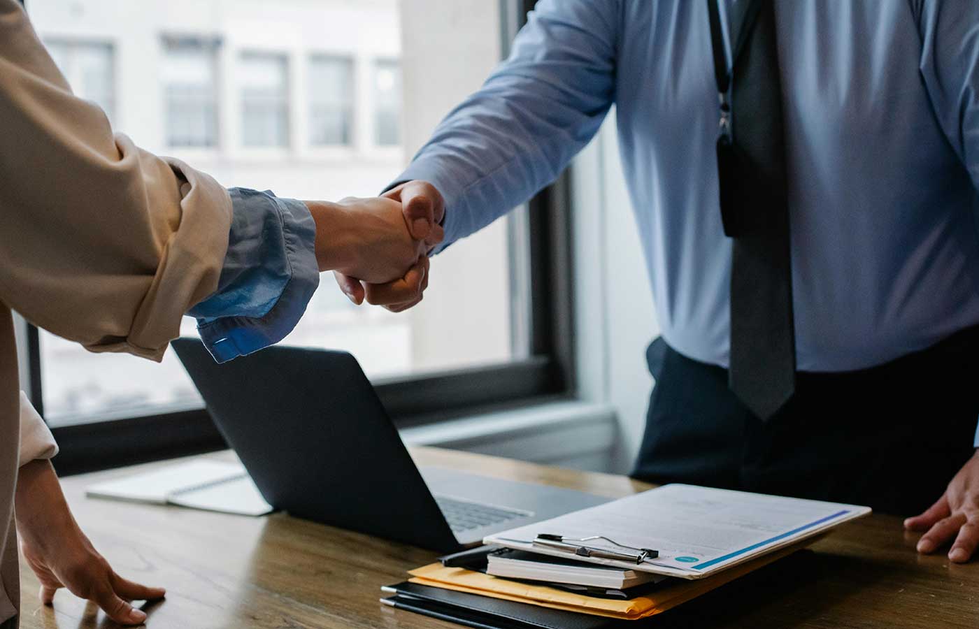 ExitMax Advisors Platform background showing two people shaking hands and selling or buying a business